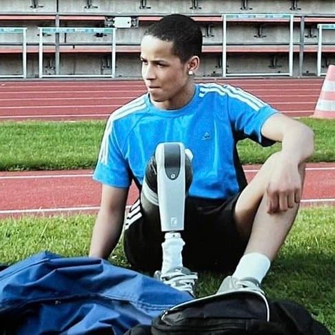 Der junge Léon Schäfer am Rand der Laufbahn mit früher Sportprothese